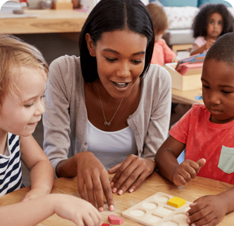 A woman and two children playing with blocks.